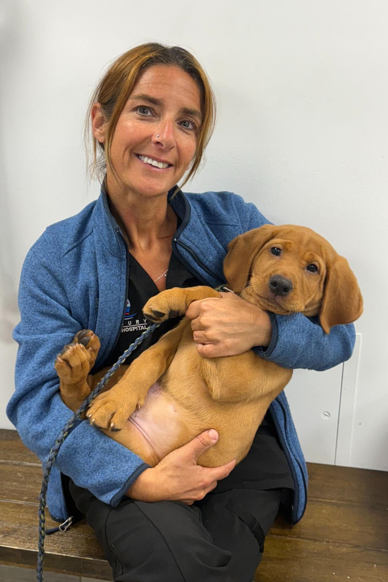 Kerry is holding Riggs, a puppy that came in for a wellness exam